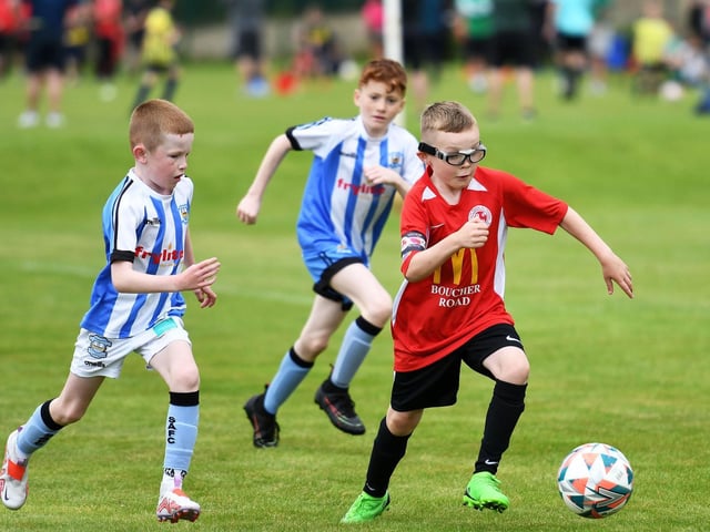 Cumann Spoirt an Phobail skipper Odhran Ferris powers past Strabane Athletic under-10's player Jack Melaugh at Oakgrove.