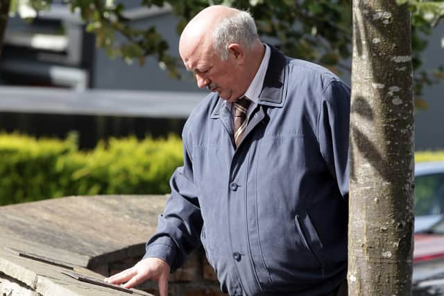 David Temple, who lost his brother William in the attack, pictured at name plaques for the victims at the memorial in the centre of Claudy village.