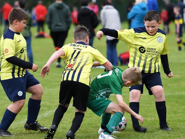 Bonagee United player Darragh McKenna is outnumbered in midfield during their match against Sion Swifts Colts under-10's.
