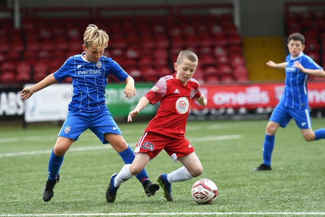 Maiden City Academy under-12's player Aedan Smith goes down in the penalty area under pressure from Coleraine's George McClean. Picture by Keith Moore