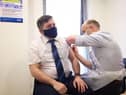 Health Minister Robin Swann receving one of his vaccines.