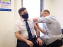 Health Minister Robin Swann receving one of his vaccines.
