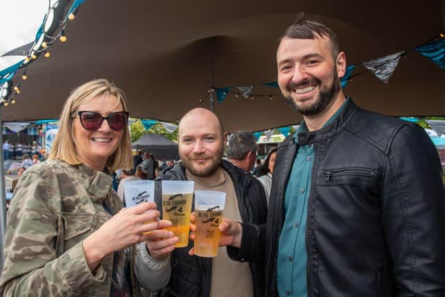Chrissie Diver, Emmett Wilson and Daniel Diver enjoy a drink at the Foyle Maritime Festival bar using their reusable plastic cup. Picture by Martin McKeown.