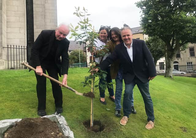 Bishop of Derry Donal McKeown is joined by John and Pat Hume's children, Mo, Therese and Aidan, to plant a tree in their memory at St Eugene's Cathedral.