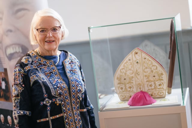 Grainne McCafferty, one of the organisers of the new exhibition chronicling the life and legacy of Bishop Edward Daly, pictured at a display featuring his mitre, crozier and skull cap.