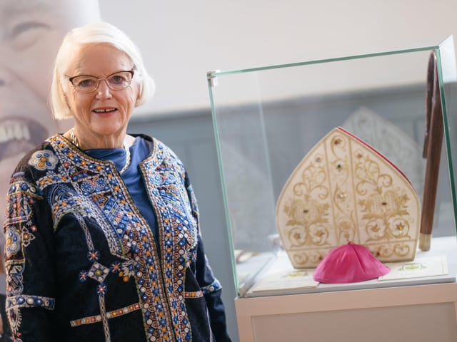 Grainne McCafferty, one of the organisers of the new exhibition chronicling the life and legacy of Bishop Edward Daly, pictured at a display featuring his mitre, crozier and skull cap.