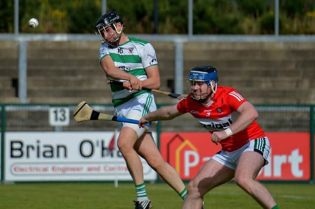 Swatragh's Fintain McGurk gets off a shot as Na Magha's Diarmuid Shiels closes in at Owenbeg on Saturday. (Photo: George Sweeney)