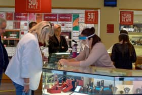 A shop assistant in a city centre jewellers wearing a face shield in early 2020. DER2027GS - 020