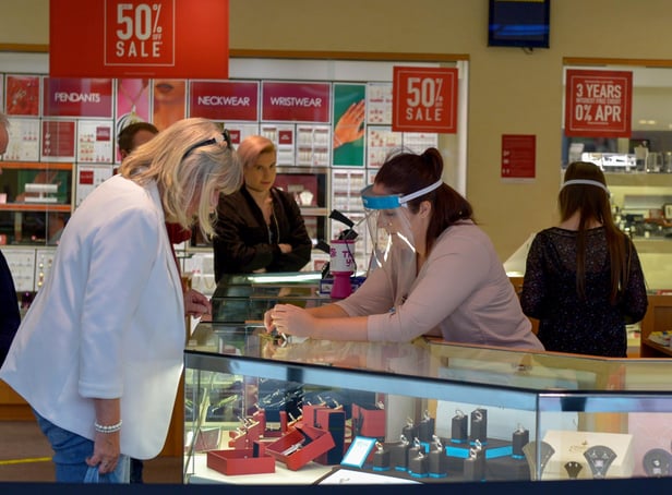 A shop assistant in a city centre jewellers wearing a face shield in early 2020. DER2027GS - 020