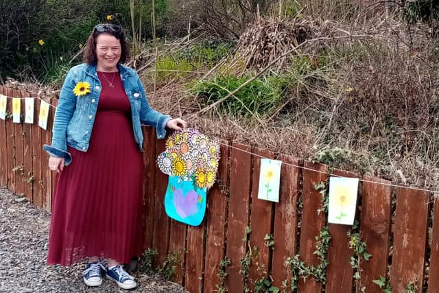 Geraldine Mullan pictured with sunflowers made by Gaelscoil Riabhach, Co. Galway
