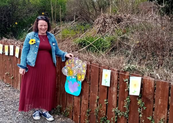 Geraldine Mullan pictured with sunflowers made by Gaelscoil Riabhach, Co. Galway