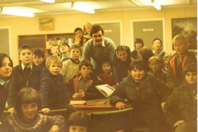 John with schoolchildren at Creggan library.