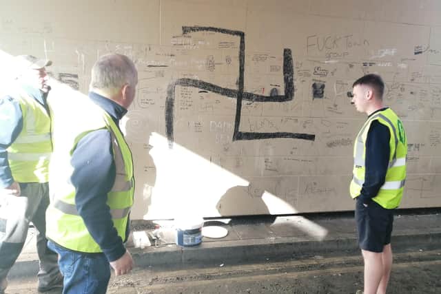 Members of the Martin McGuinness Cumann get ready to paint out the offensive graffiti.