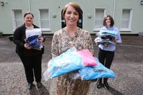 Orla Ward from O’Neills, presenting an initial batch of clothing to Foyle Women’s Aid representative Joanne Miller (left), and Denise McQuillan, for The Rowan (SARC). The local sportswear manufacturer is donating hundreds of clothing items which individuals referred to the regional centre can change into when leaving.