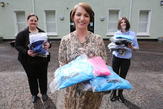 Orla Ward from O’Neills, presenting an initial batch of clothing to Foyle Women’s Aid representative Joanne Miller (left), and Denise McQuillan, for The Rowan (SARC). The local sportswear manufacturer is donating hundreds of clothing items which individuals referred to the regional centre can change into when leaving.