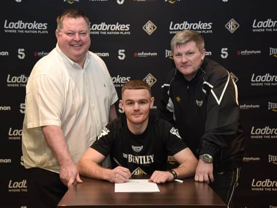 Brett McGinty signs his contract with Hennessy Sports overseen by Mick Hennessy and trainer Ricky Hatton