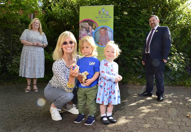 Health Minister Robin Swann with the Chief Executive of the Northern Ireland Childminder Association (NICMA), Patricia Lewsley-Mooney and childminder Joan Boyd with Henry and Margo