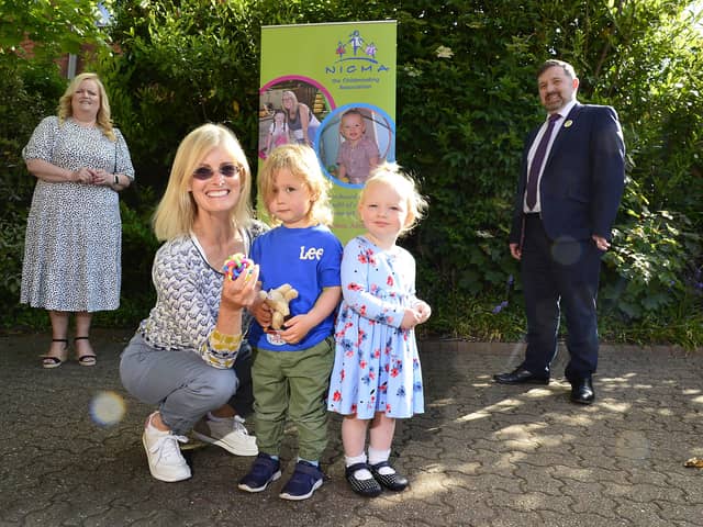 Health Minister Robin Swann with the Chief Executive of the Northern Ireland Childminder Association (NICMA), Patricia Lewsley-Mooney and childminder Joan Boyd with Henry and Margo