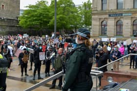 A female PSNI officer videos people attending the recent Justice for George Floyd rally held in Guildhall Square. DER2320GS – 039