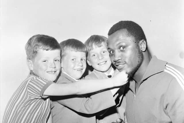Ciaran Doherty from Belmont Crescent,and the brothers Edmund and Seamus McIntyre of Gartan Square meet world heavyweight champ Joe Frazier during his visit to Derry.