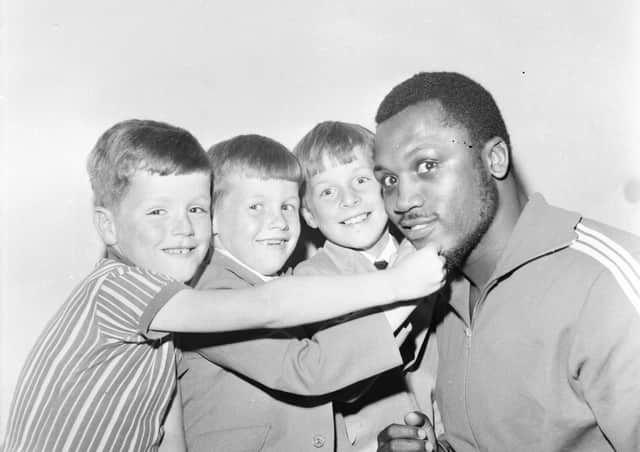Ciaran Doherty from Belmont Crescent,and the brothers Edmund and Seamus McIntyre of Gartan Square meet world heavyweight champ Joe Frazier during his visit to Derry.