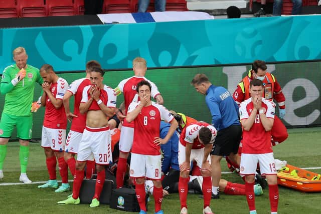 Andreas Christensen of Denmark looks dejected whilst team mate Christian Eriksen (hidden) receives medical treatment during the UEFA Euro 2020 Championship Group B match between Denmark and Finland last weekend.