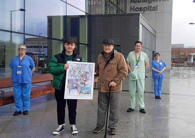 Ethan Deery and his grandfather Neil present pictures to staff at Altnagelvin Hospital.