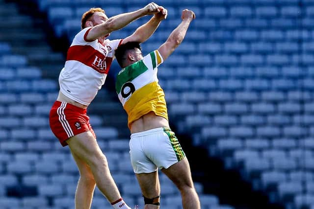 Conor Glass takes to the skies to break a high ball against Offaly's Eoin Carroll in Croke Park on Saturday. (Photo: Lorraine O'Sullivan/INPHO)