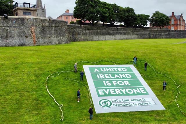 Sinn Féin activists unfurl the banner in the Bogside.