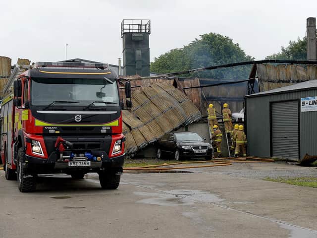 Firefighters at the scene of aftermath of the blaze on Railway Street, Strabane, that destroyed a coffin-making business on Sunday afternoon last. Photo: George Sweeney / Derry Journal.  DER2127GS – 005