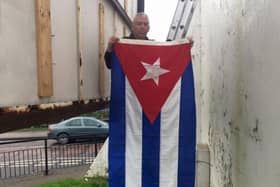 Sinn Féin activist Mickey Kinsella raising the Cuban flag at Free Derry Corner to mark the death of Fidel Castro in 2016.