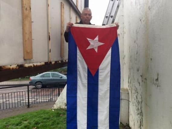 Sinn Féin activist Mickey Kinsella raising the Cuban flag at Free Derry Corner to mark the death of Fidel Castro in 2016.