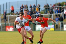 Derry’s  Ryan McNicholl pulls away from Armagh’s Michael Burnett and Fergal O’Brien during Wednesday evening’s  game at Owenbeg. (Photo: George Sweeney).