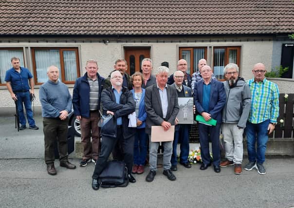 Sammy McDevitt holds a picture of his late brother Eamon (inset) with Paul O’Connor of the Pat Finucane Centre and members of the deaf community who travelled from across Ireland