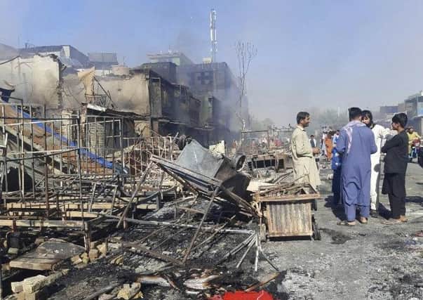 Afghans inspect damaged shops after fighting between Taliban and Afghan security forces in Kunduz city, northern Afghanistan, Sunday, Aug. 8, 2021. (AP Photo/Abdullah Sahil)