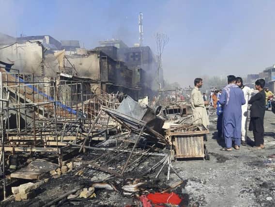 Afghans inspect damaged shops after fighting between Taliban and Afghan security forces in Kunduz city, northern Afghanistan, Sunday, Aug. 8, 2021. (AP Photo/Abdullah Sahil)