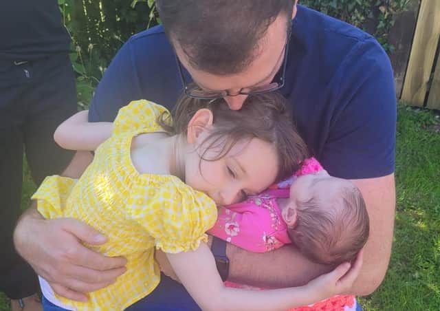 Josh Willis cradles his daughters Lilyanna (4) and Eviegrace (three weeks).