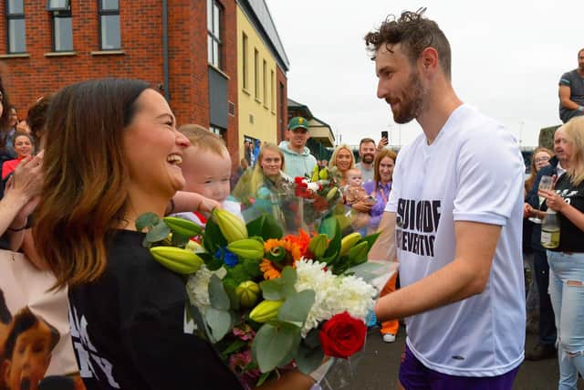 Sporting hero Danny Quigley presents his partner Emear with flowers on his arrival at Destined after completing a gruelling 10 Ironman Triathlons in 10 days in memory of his dad and fundraising over £74,000 for charities.  Photo: George Sweeney / Derry Journal.  DER2135GS – 026