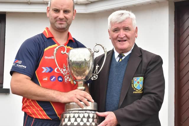 Brigade skipper Andy Britton is presented with the North West Senior Cup by Association President, Mr. Connie McAllister. (Photo: Lawrence Moore)