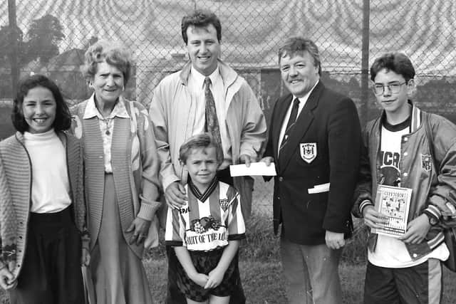 Jack McCauley, chairman , Derry City FC, receives a sponsorship cheque for the Brandywell club’s clash with Mexican side, Los Pumas, from Paul Diamond, of Diamond Corrugated Cases in 1991. Included at front wearing Derry jersey, is Paul’s son Niall.