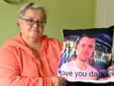 Ruth Bone holding a memento of her late son Dale.