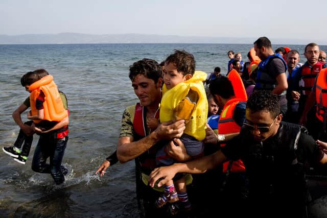Syrian migrants arrive at the coast on a dinghy after crossing from Turkey, at the island of Lesbos, Greece, in 2015