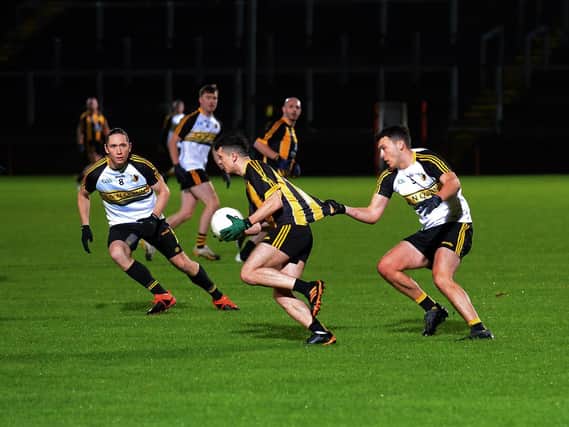 Doire Colmcille's Joe McCartie tugs at the jersey of Ardmore's Jordon Barrow during Friday evening's game in Celtic Park. Photo: George Sweeney