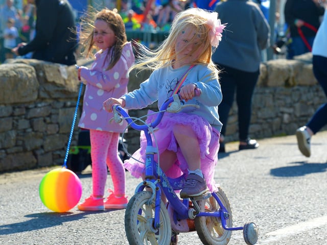 A young girl makes her way to the finish line in the Pedal Powered Tractor Run and Doll Push race at the Greencastle Regatta on Friday afternoon last. Photo: George Sweeney.  DER2231GS – 077