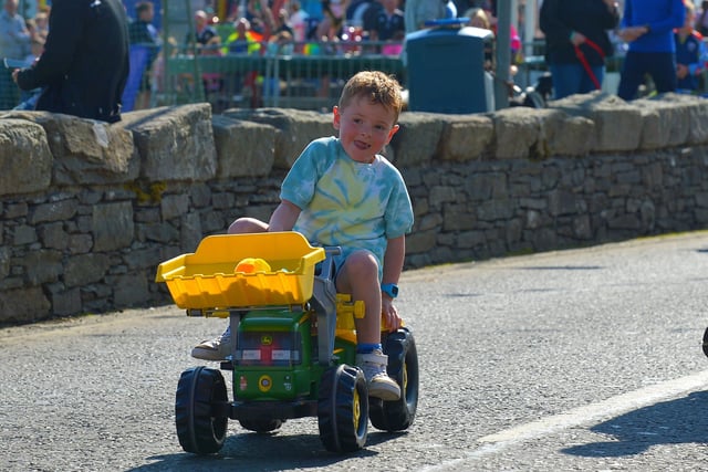 This young man is determined to finish the Pedal Powered Tractor Run and Doll Push race held during the Greencastle Regatta on Friday afternoon last. Photo: George Sweeney.  DER2231GS – 075