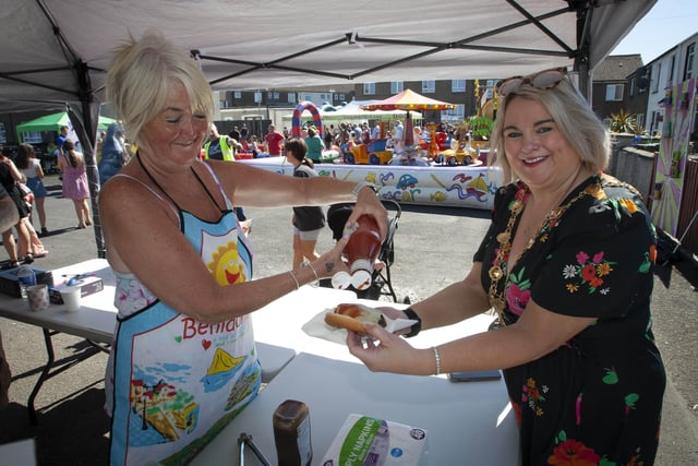 Yvonne Graham helps Mayor Sandra Duffy with ketchup for her burger at Thursday's Leafair Fun Day.