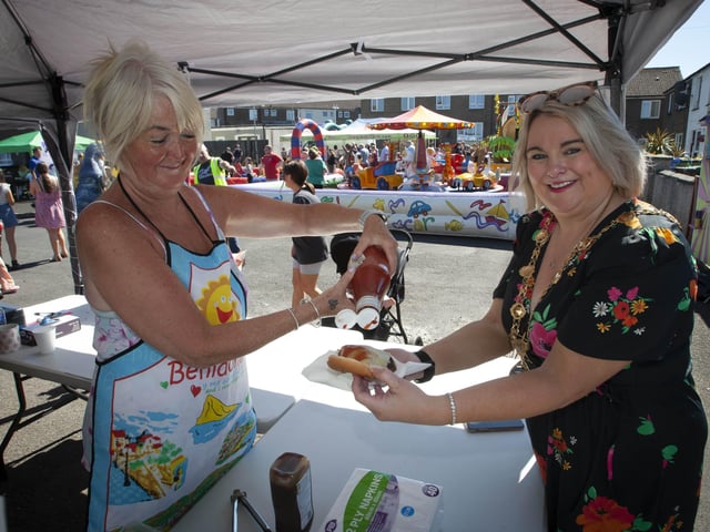Yvonne Graham helps Mayor Sandra Duffy with ketchup for her burger at Thursday's Leafair Fun Day.