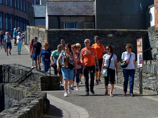 Visitors enjoy the sunshine and a walk on Derry’s historic Walls yesterday afternoon. Photo: George Sweeney. DER2232GS – 023