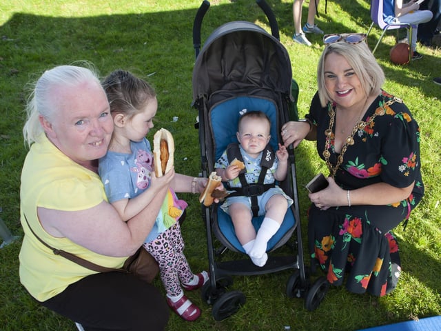 ENJOYING HIS BURGER!. . . . Mayor Sandra Duffy pictured with Regina Farren and Anna (4) and Oisin (1) during the Shantallow 'Party in the Park' on Thursday.