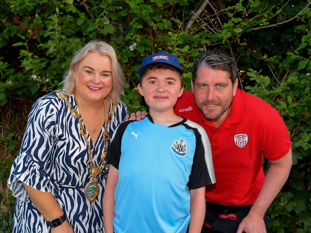 Fifteen-year-old Niall O’Doherty pictured with mayor Sandra Duffy and Derry City manager Ruaidhrí Higgins before setting off on his walk, on Saturday morning, from Bay Road to the Peace Bridge, to raise money for Action Duchenne Photo: George Sweeney. DER2232GS – 044